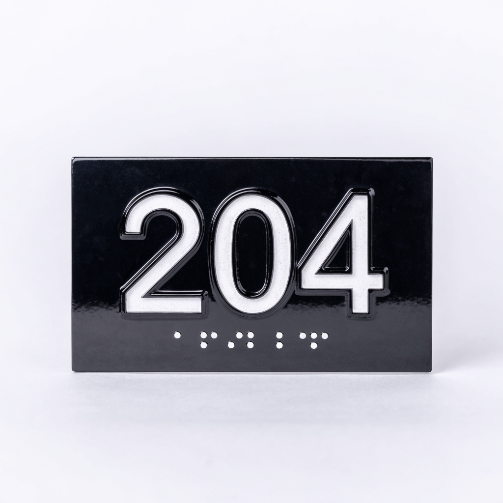 Plaque de chambre noire avec le numéro 204 en relief et transcription braille en dessous