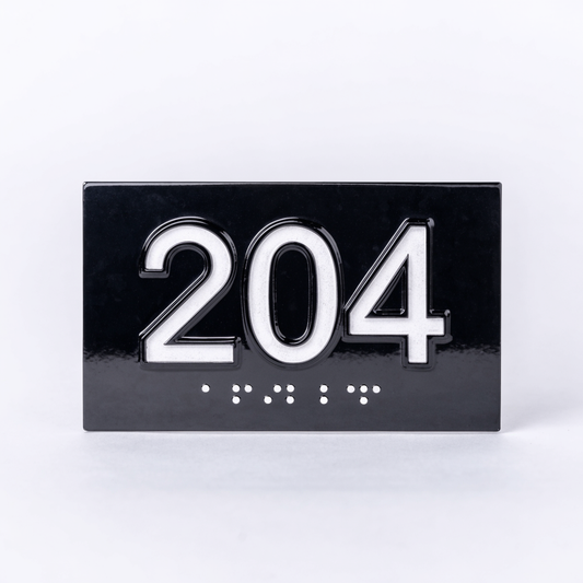 Plaque de chambre noire avec le numéro 204 en relief et transcription braille en dessous