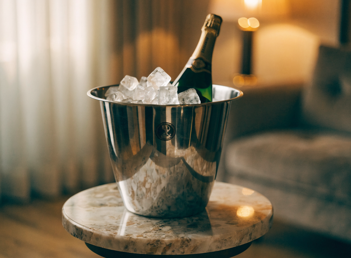 Seau à champagne marqué, garni de glace et d'une bouteille, dans une suite d'hôtel