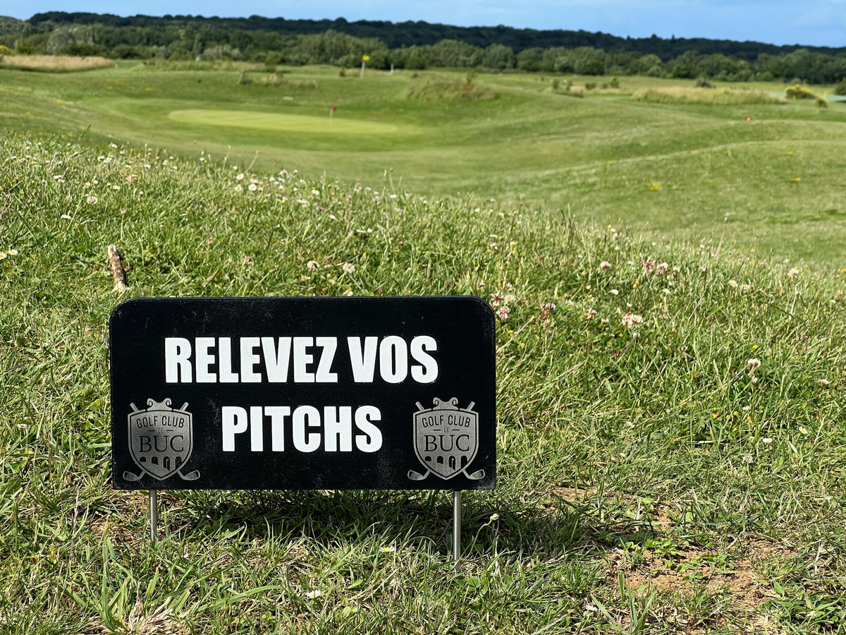 Panneau de parcours « Relevez vos pitchs » gravé au laser, logos du Golf Club de Buc, planté au bord d'un green